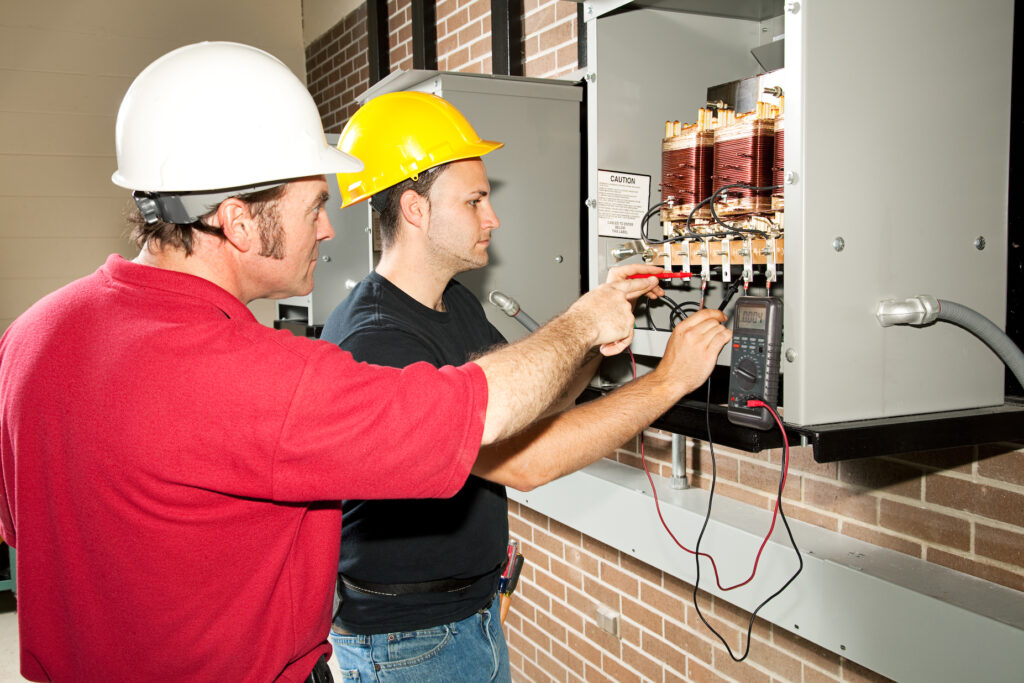 Vocational education student learns how to repair an industrial power distribution center.